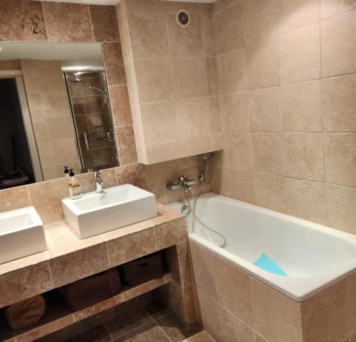 een badkamer met een wastafel en een bad bij House with sea view in the Hypercentre in Trouville-sur-Mer