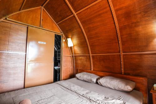 a bed in the back of a boat with wooden walls at The Polumb Garden Bedugul in Tabanan