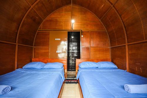 two beds in a room with an arched ceiling at The Polumb Garden Bedugul in Tabanan