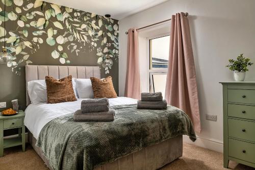 a bedroom with a bed with towels on it at Finest Retreats - Peace Retreats Penthouse in Pwllheli