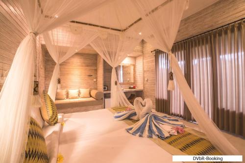 レンボンガン島にあるDayung Villas By Reccomaのベッドルーム(カーテン付きのベッド1台付)
