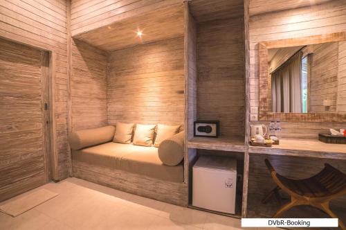 um pequeno quarto com uma cama e um espelho em Dayung Villas By Reccoma em Nusa Lembongan