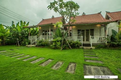 a house with a green lawn in front of it at Dayung Villas By Reccoma in Nusa Lembongan