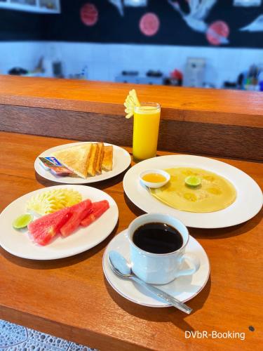 a table with two plates of food and a cup of coffee at Dayung Villas By Reccoma in Nusa Lembongan