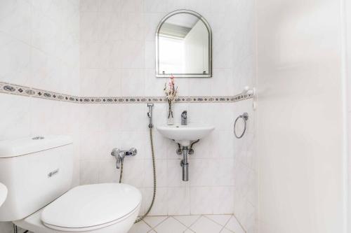 La salle de bains blanche est pourvue de toilettes et d'un lavabo. dans l'établissement Villa Lilly Rose, à Pólis Chrysochoús