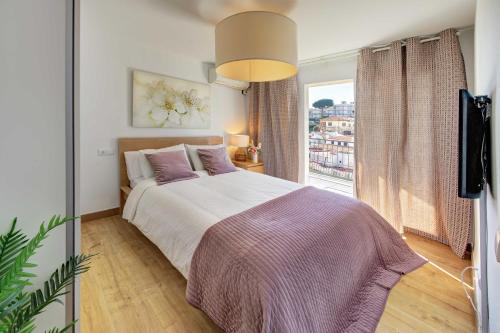 Un dormitorio con una cama grande y una ventana en APARTAMENT PAU CASALS, 2 min walk from the sea & sea view, en Lloret de Mar