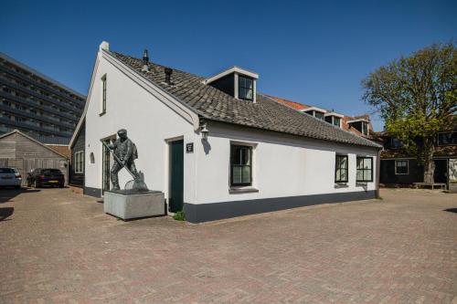 a small white building with a statue in front of it at De Kroft Beach Residences Noordwijk aan Zee in Noordwijk