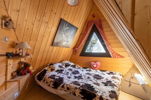 レ・ザングルにあるChalet des Pyramidesの木造キャビン内のベッド1台が備わるベッドルーム1室を利用します。