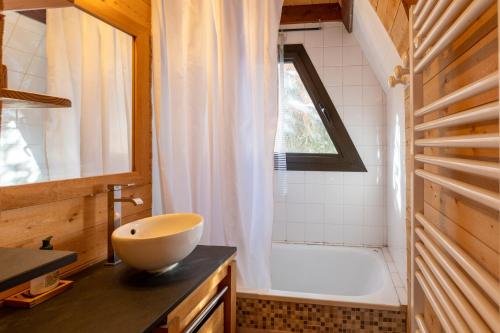レ・ザングルにあるChalet des Pyramidesのバスルーム(ボウルシンク、バスタブ付)