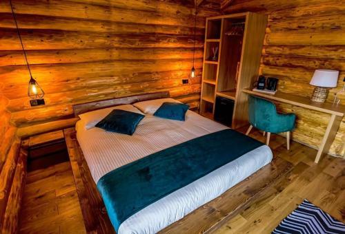 a bedroom with a bed in a log cabin at Complex Bosco in Borşa