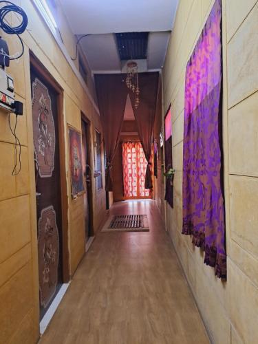 a long hallway with paintings on the walls at Bob Cafe & Guest House Jaisalmer in Jaisalmer