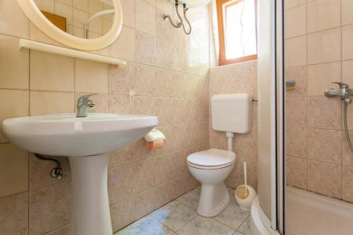 een badkamer met een wastafel, een toilet en een douche bij Apartments Magdalena in Malinska