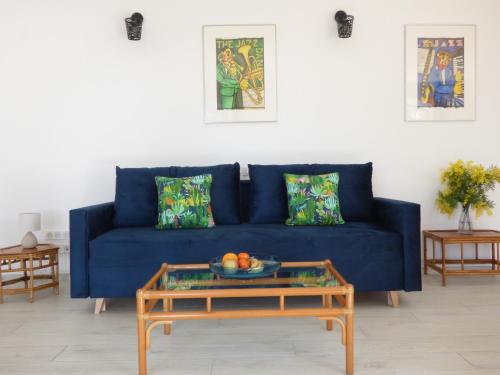 Sofá azul en la sala de estar con mesa en Apartment Cézanne mit geheiztem Pool und Privatgarten en Châteauneuf