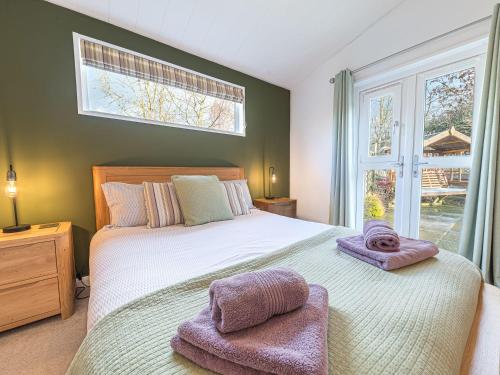 格蘭奇奧沃桑茨的住宿－Fern Lodge，一间卧室配有一张大床和两条毛巾