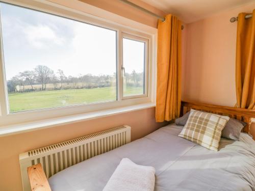ein Schlafzimmer mit einem Bett und einem großen Fenster in der Unterkunft Fairview House in Kidderminster