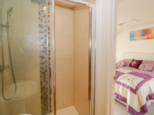 a bathroom with a shower next to a bed at Fairview House in Kidderminster