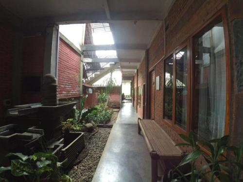 a hallway of a building with a bench and plants at Istana Petani in Lambangkuning