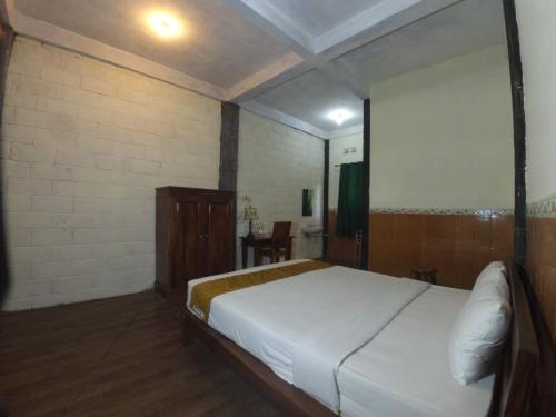 a bedroom with a large white bed in a room at Istana Petani in Lambangkuning