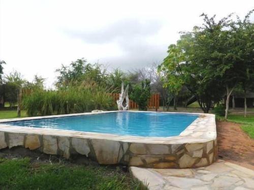 een zwembad met een stenen muur eromheen bij Fiume Lodge CC in Grootfontein