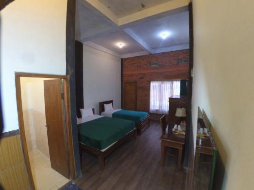 a bedroom with two beds and a large mirror at Istana Petani in Lambangkuning