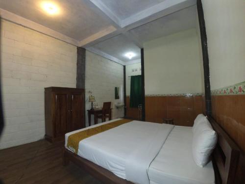 a bedroom with a large white bed in a room at Istana Petani in Lambangkuning