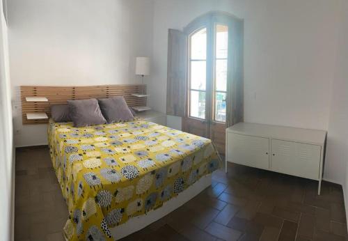 ein Schlafzimmer mit einem Bett mit einer gelben Decke in der Unterkunft Apartamento de diseño cerca de tren, playa y BCN in Masnou