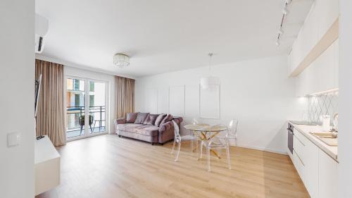 a white living room with a couch and a table at Apartamenty Sun & Snow Double Rest in Jastrzębia Góra