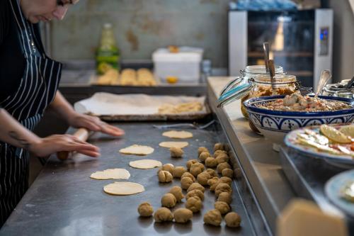 a woman preparing food on a counter in a kitchen at Akotika boutique in ‘Akko