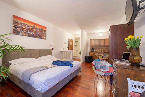 1 dormitorio con 1 cama y escritorio con ordenador portátil en Aurelia Luxury - Piazza delle Erbe en Verona