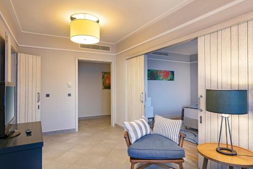 a living room with a blue chair and a lamp at Xanadu Island in Akyarlar