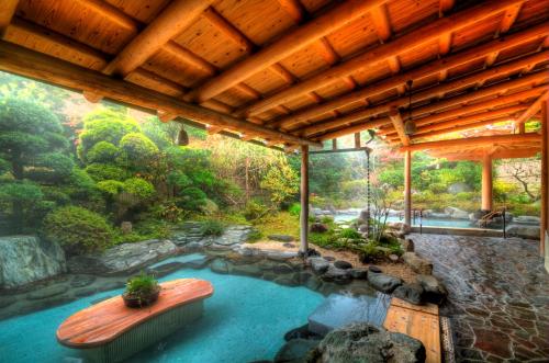 a swimming pool in a house with a wooden ceiling at Yoshiike Ryokan in Hakone