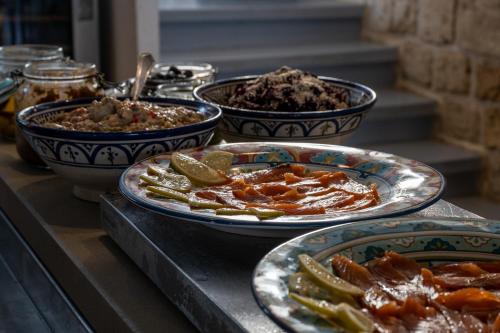 a buffet with plates of food on a table at Akotika boutique in ‘Akko