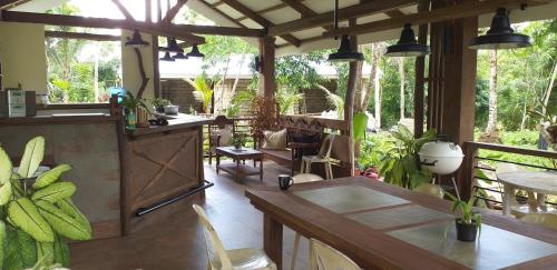 una cocina al aire libre con mesas y sillas en un patio en Forest garden residence, en Bilar
