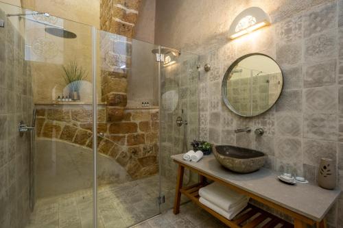 a bathroom with a sink and a shower with a mirror at Akotika boutique in ‘Akko