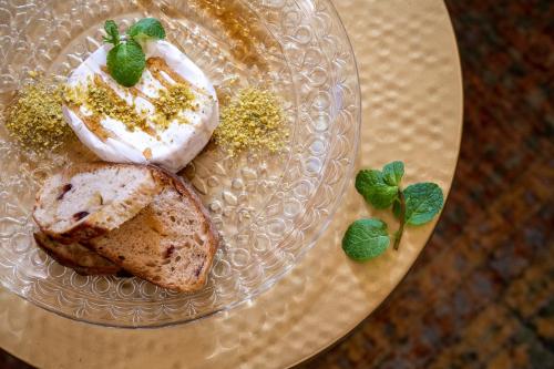 a glass plate with a piece of cake and whipped cream at Akotika boutique in ‘Akko