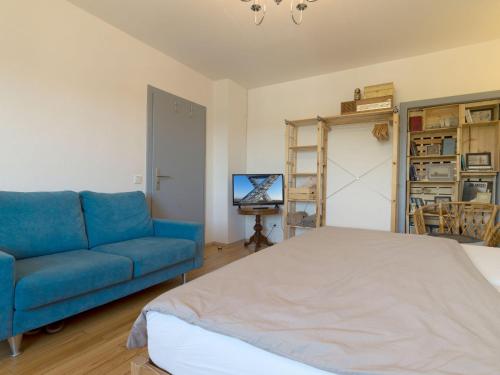 a living room with a blue couch and a television at Müllers WohnRäume in Saarlouis