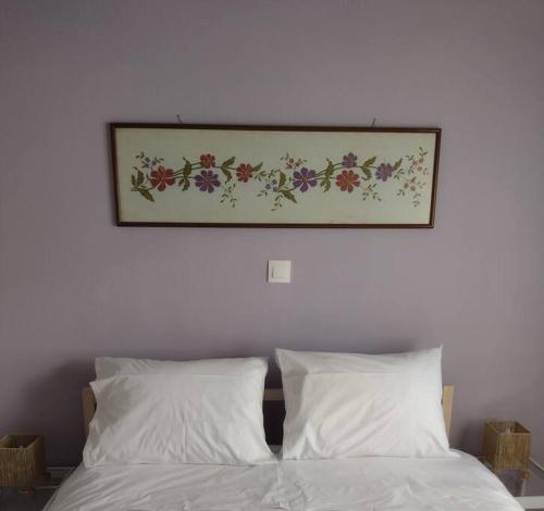 a picture above a bed with white sheets and pillows at Snowbird-late check-out in Ierapetra