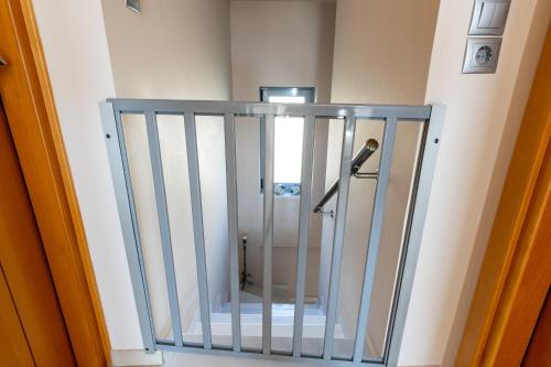 a metal gate in a room with a toilet at Elegant new maisonette near the sea in Egina
