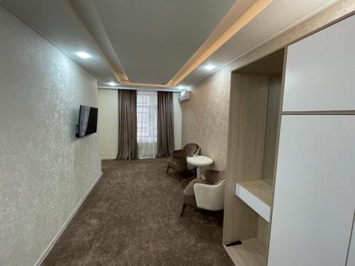 a room with a waiting room with a tv and chairs at Chinor Hotel Fergana in Fergana