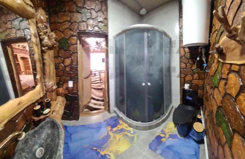 a bathroom with a large mirror and a stone wall at Кереге-Таш in Karakol