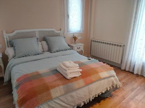 a bedroom with a bed with towels on it at Apartamentos Antonia in Cuzcurrita-Río Tirón