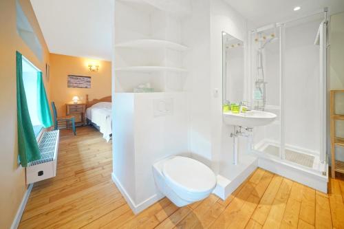 uma casa de banho com um WC, um chuveiro e um lavatório. em Gîte de la Forêt em Theux
