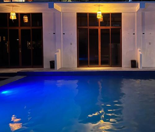 a house with a blue swimming pool at night at LaZerena Lodge in Zambales