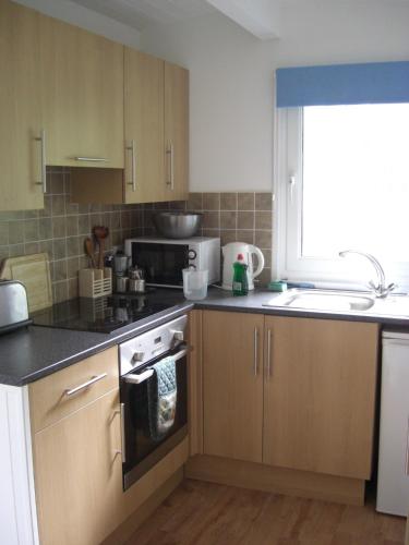 a kitchen with a sink and a stove top oven at Whiteshell Chalets in The Mumbles