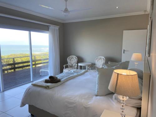 a bedroom with a bed with a view of the ocean at Loerie Nest in Port Alfred