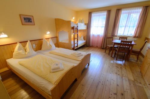 a hotel room with a large bed and a table at JUFA Hotel Donnersbachwald in Donnersbachwald