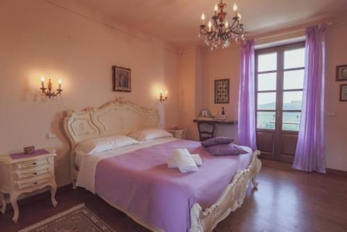 um quarto com uma cama com lençóis roxos e uma janela em Agriturismo Tre Stelle em Barbaresco