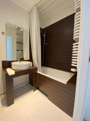a bathroom with a sink and a bath tub at Ann's Apartment in Białystok