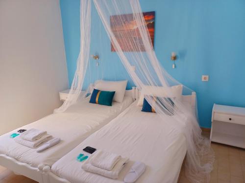 a bedroom with a bed with a mosquito net at Stamatia's Houses in Agios Georgios