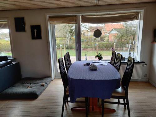 comedor con mesa azul y sillas en Vidunderligt hus i landlige omgivelser, en Spottrup